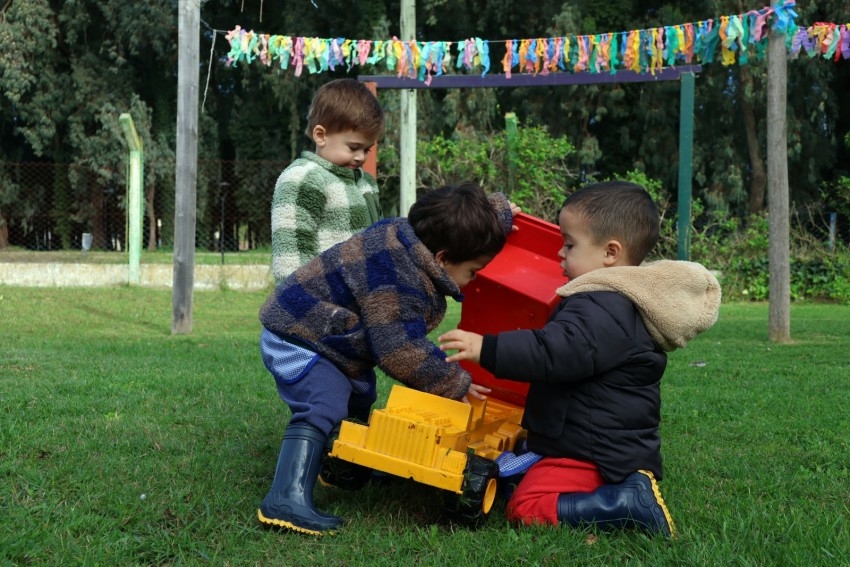 Niños juegan con un camión de juguete en una actividad al aire libre