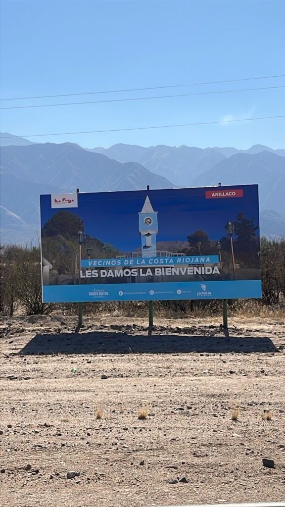 Cartel de ingreso a Anillaco, La Rioja, con la sierra de fondo
