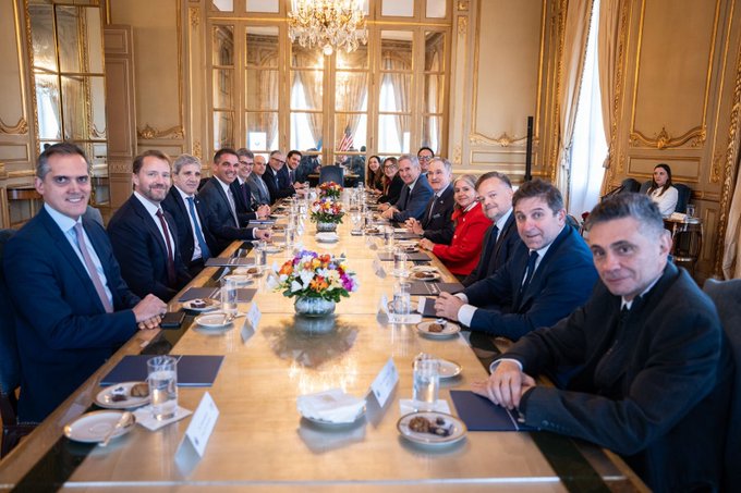 Participantes del encuentro sentados alrededor de una mesa en un salón institucional.